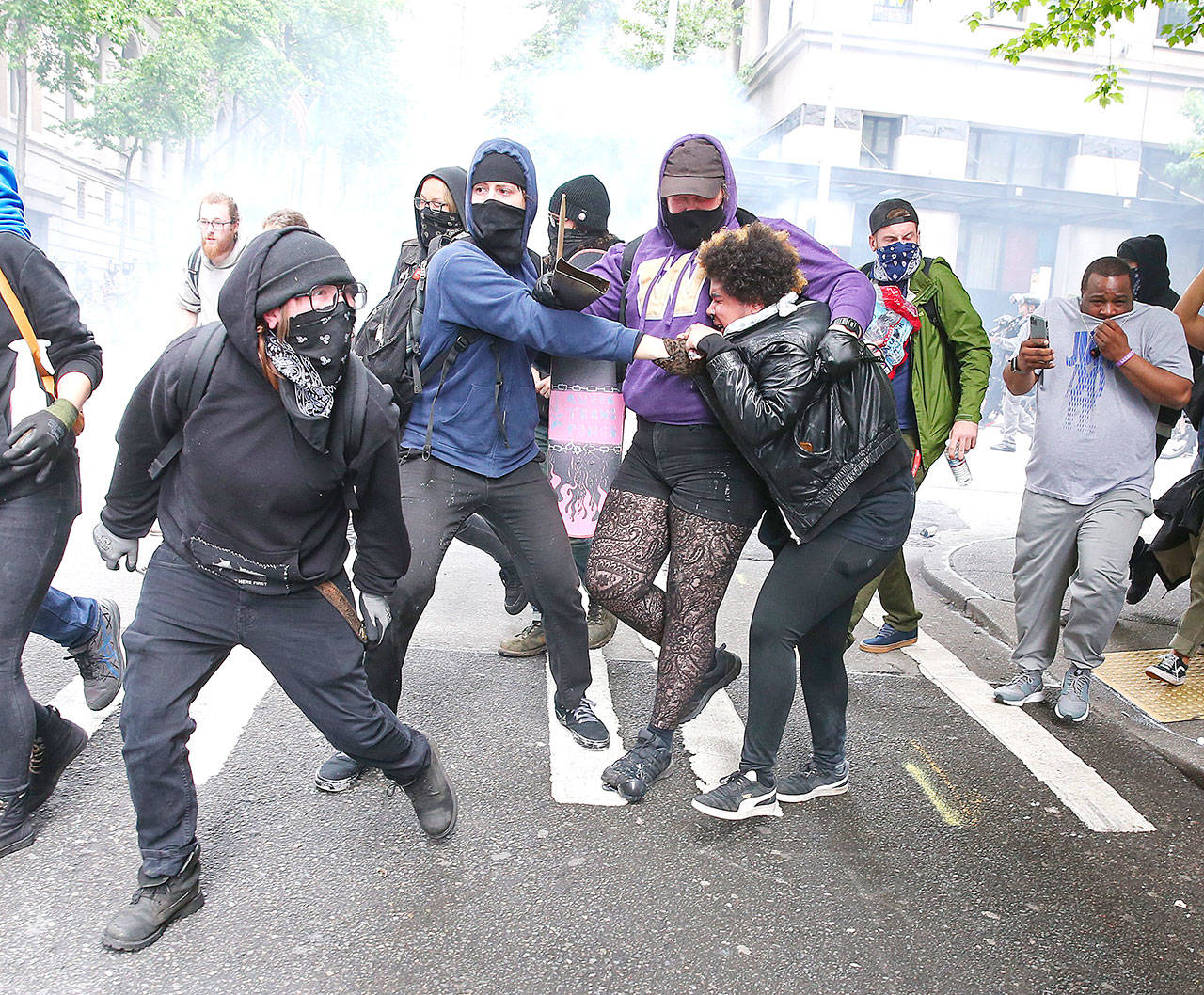 Protesters run from flashbangs in downtown Seattle on May 31 during protests over the death of George Floyd in Minneapolis. (Ken Lambert/Seattle Times)