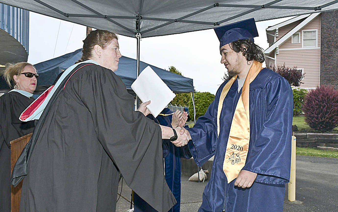 DARRELL WESTMORELAND PHOTO                                 A parade honoring Aberdeen High School’s Class of 2020 June 12 ended at Stewart Field, where Jacob Lafountaine shook hands with Principal Sherri Northington.
