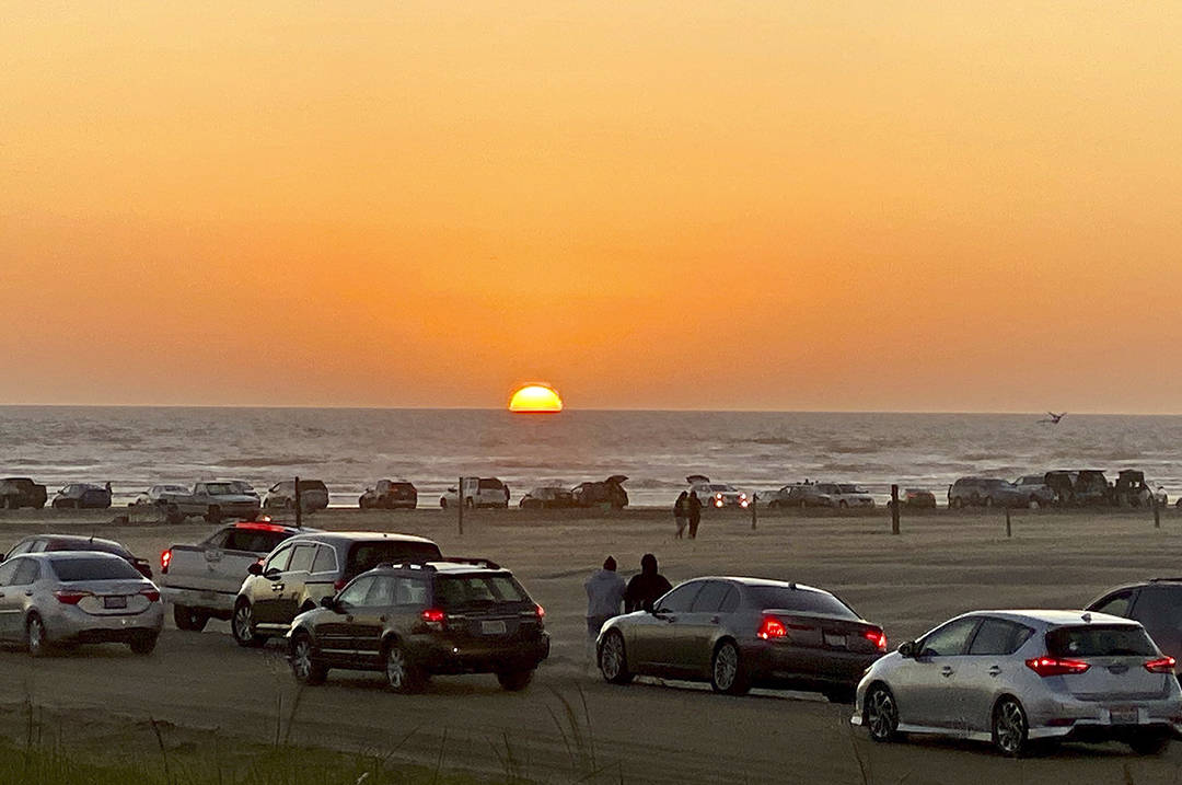 Robert Smyth photo                                Vehicles crowd the beach at Ocean Shores to view the sunset on Saturday.