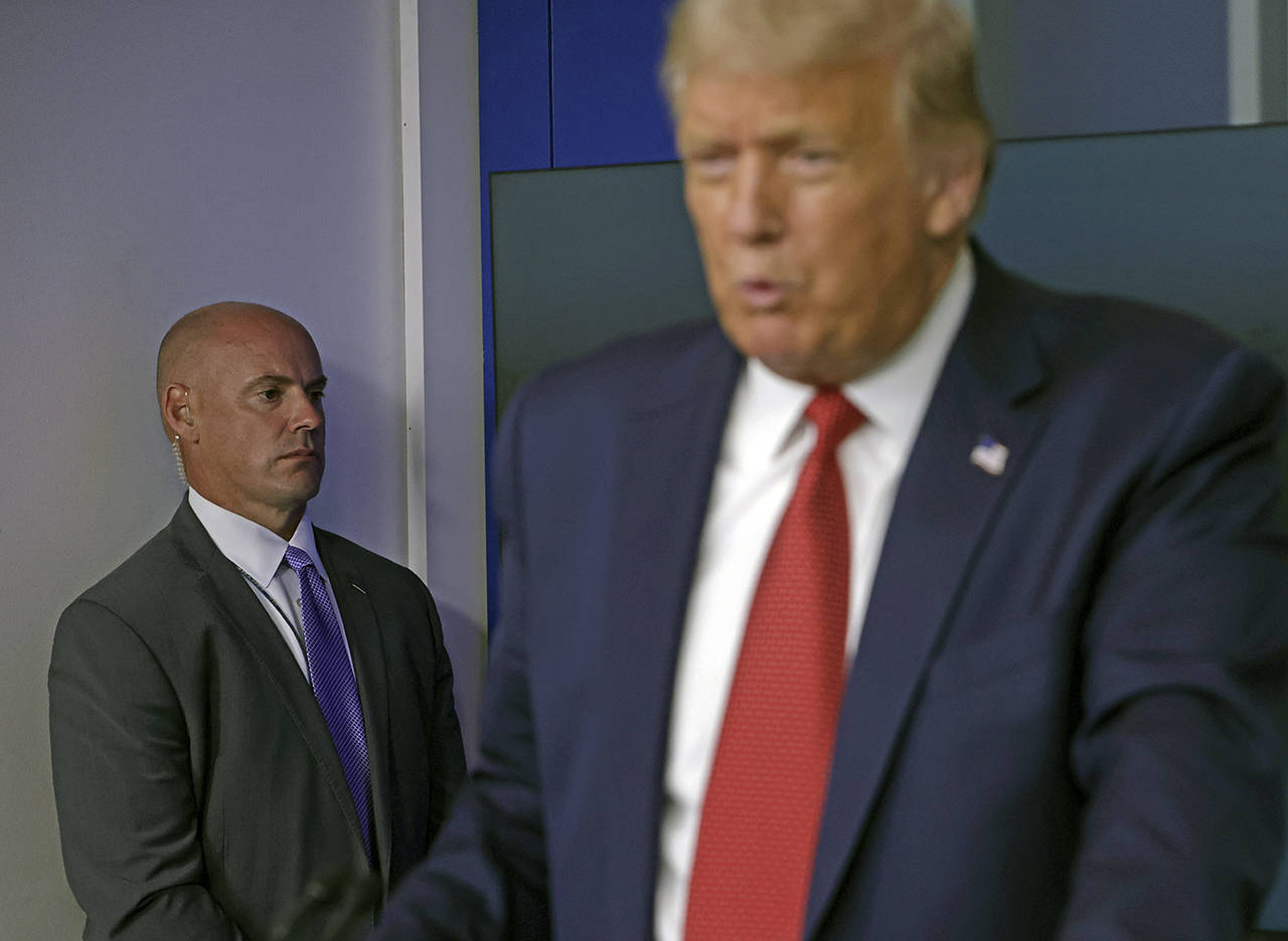 A Secret Service agent stands near President Donald Trump while he speaks at a news conference at the White House on Monday. The news conference was interrupted by an active shooter outside the White House. (Alex Wong | Getty Images)