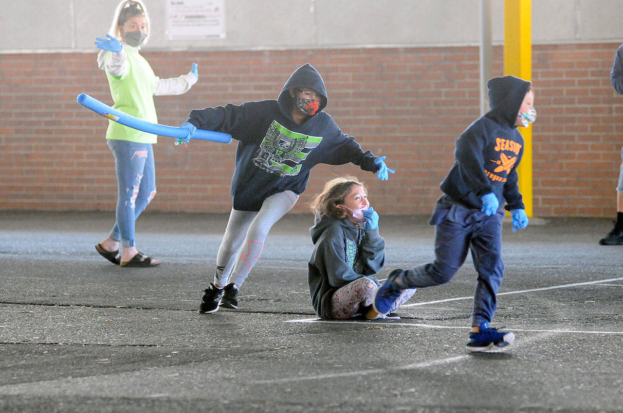 Students play a socially distanced version of “Duck Duck Goose” as YMCA youth mentor Chayanne Baker, left, looks on during the Harbor After School program on Wednesday at A.J. West Elementary School in Aberdeen. (Ryan Sparks | Grays Harbor News Group)