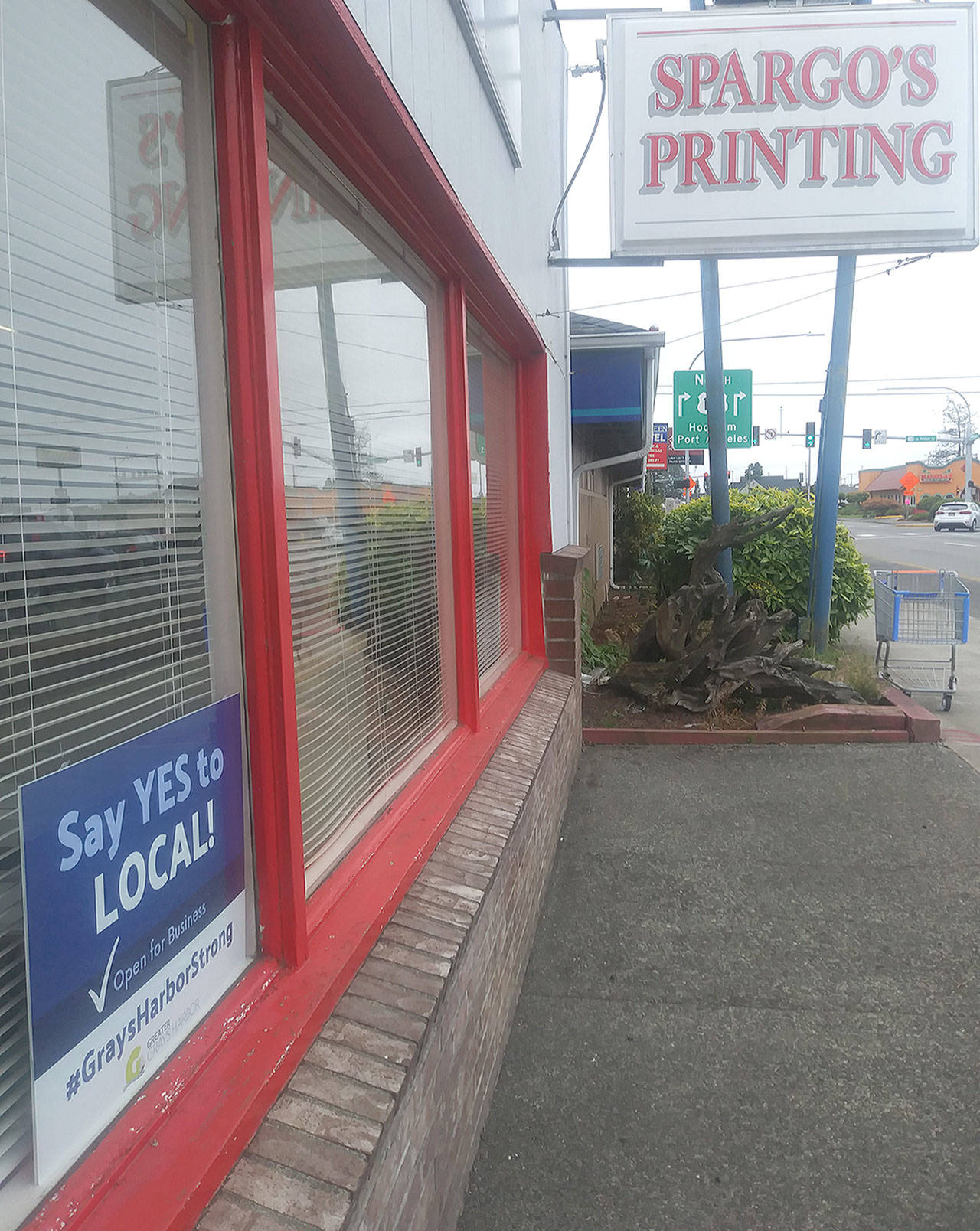 A “Say YES to LOCAL” sign appears outside the storefront of Spargo’s Printing in Aberdeen, where they were created. (David Haerle/The Daily World)