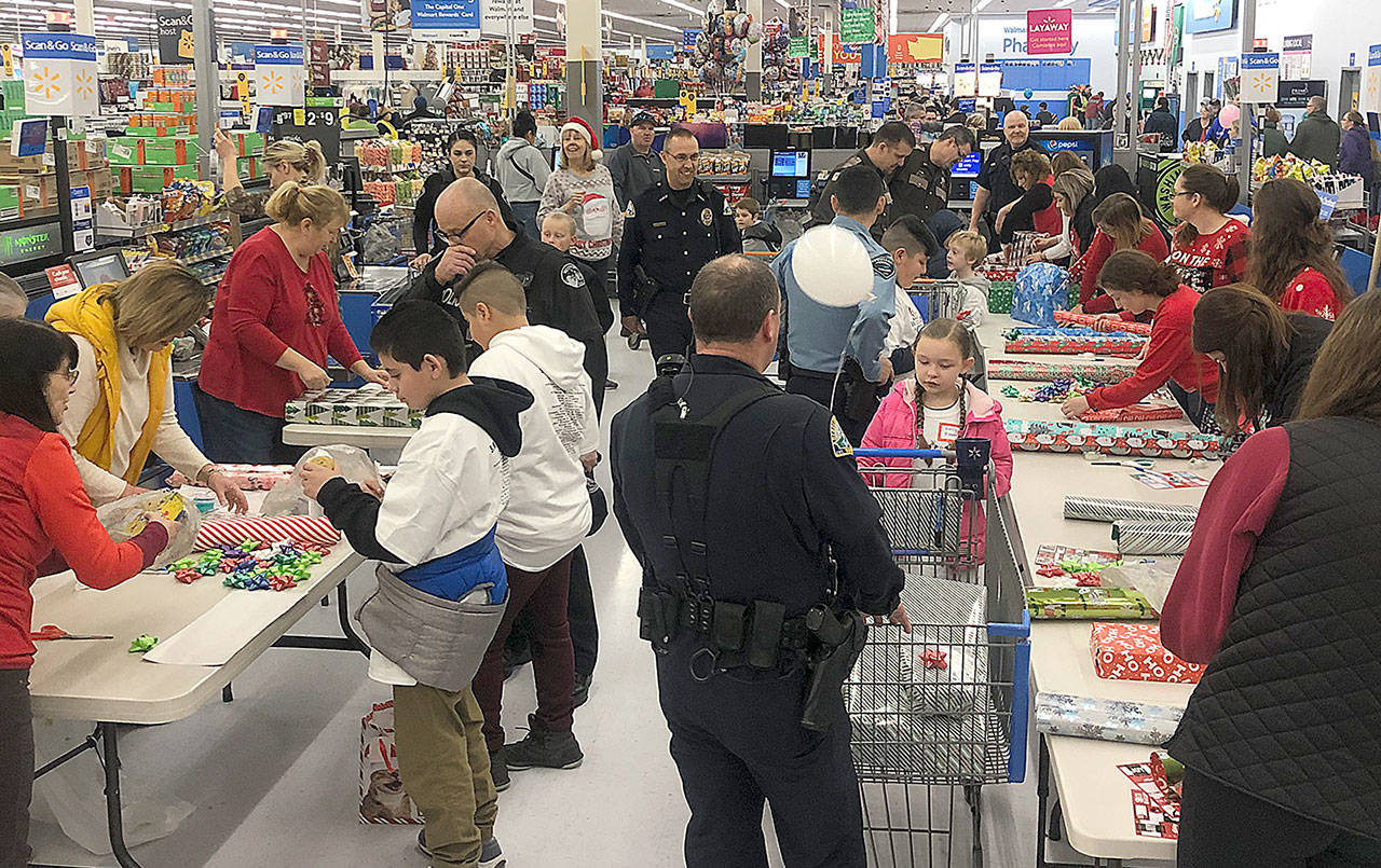 FILE PHOTO                                 Last year’s Shop with a Cop had about 60 kids and law enforcement from around the county buying and wrapping gifts at Walmart. This year’s event has been canceled due to COVID-19, but the Hoquiam Police Department is working on plans for a modified event to help local families in need.