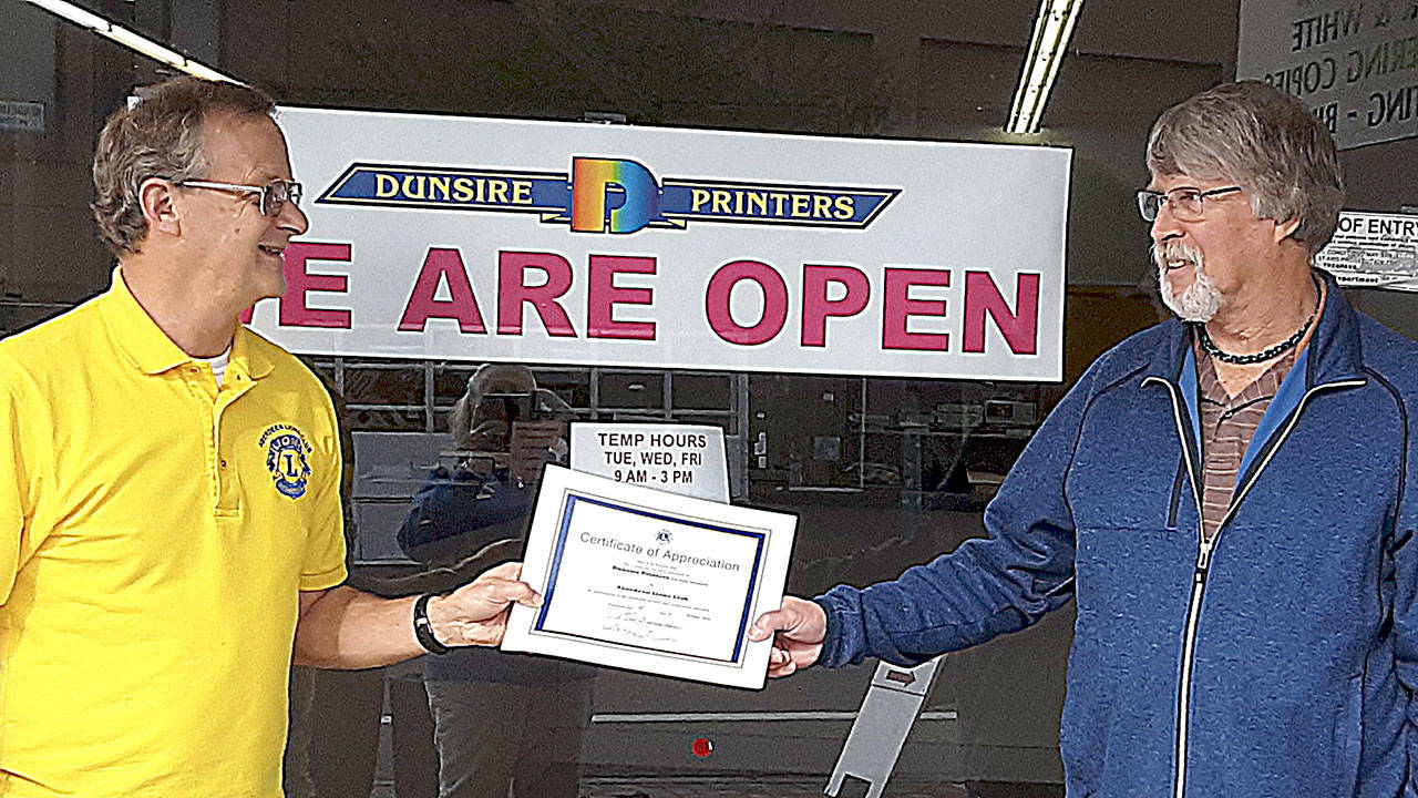 Aberdeen Lions member Greg Johnstone presents a certificates of appreciation to Sandy Dunsire of Dunsire Printers.