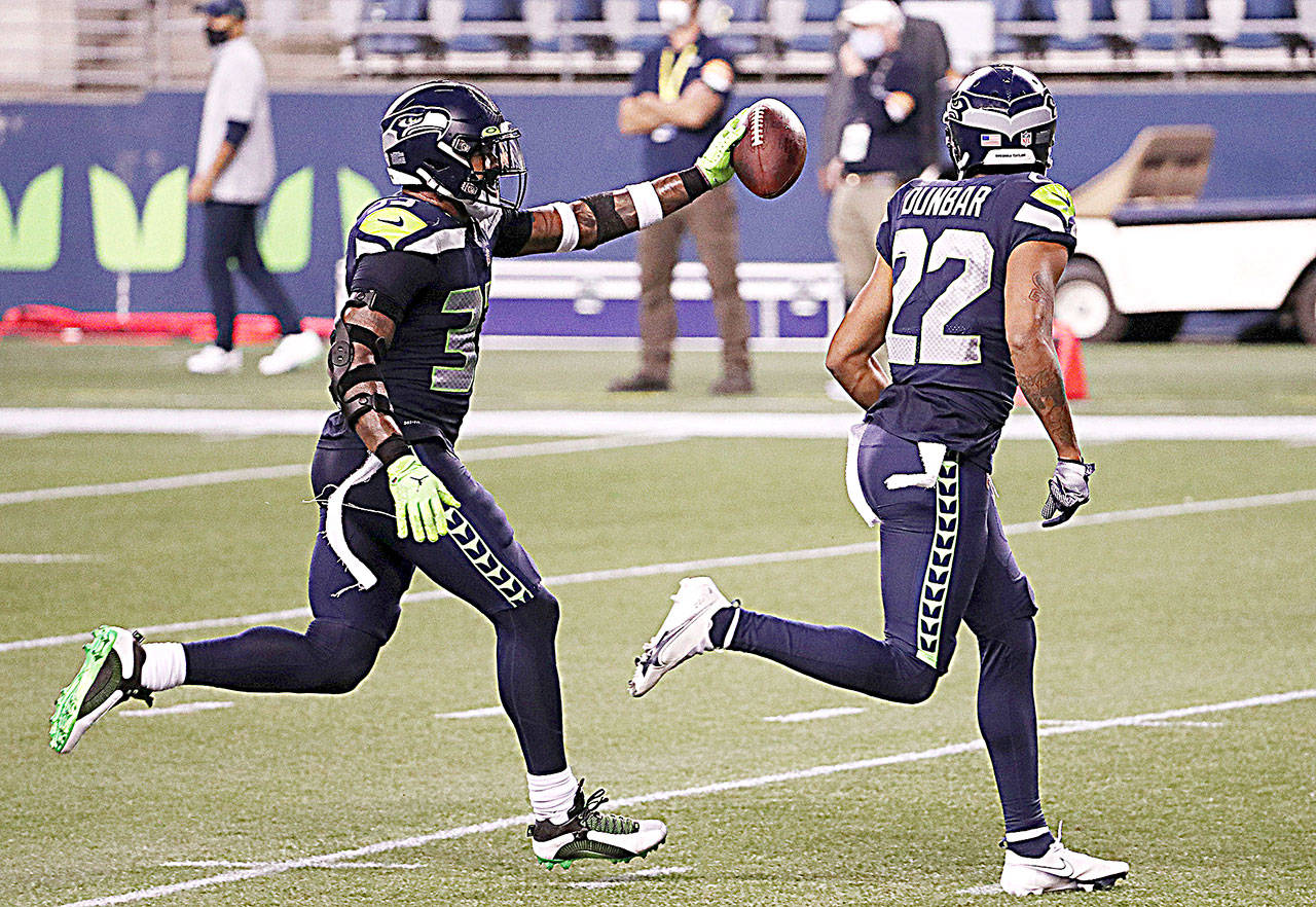 Seattle Seahawks safety Jamal Adams, left, celebrates with teammate Quinton Dunbarafter intercepting a pass on Sept. 20 against the New England Patriots at CenturyLink Field in Seattle. (Abbie Parr/Getty Images)