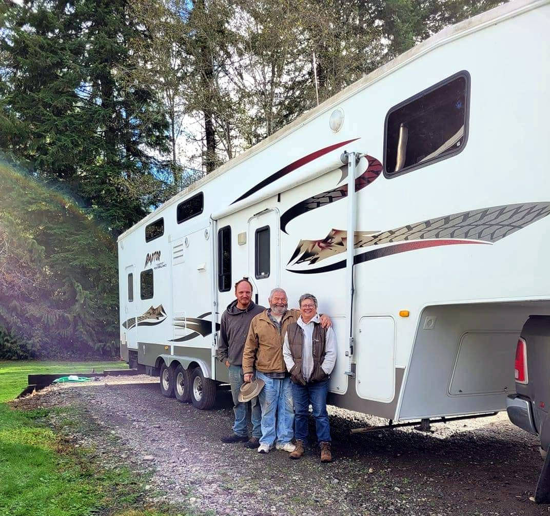Photo courtesy of Eileen Birdsong Montesano couple John and Janet Workman, pictured here with their neighbor Danny Russell (far left), stand near a fifth-wheel trailer just before donating it to a family in Bridgeport whose home was destroyed by the Pearl Hill Fire in early September.