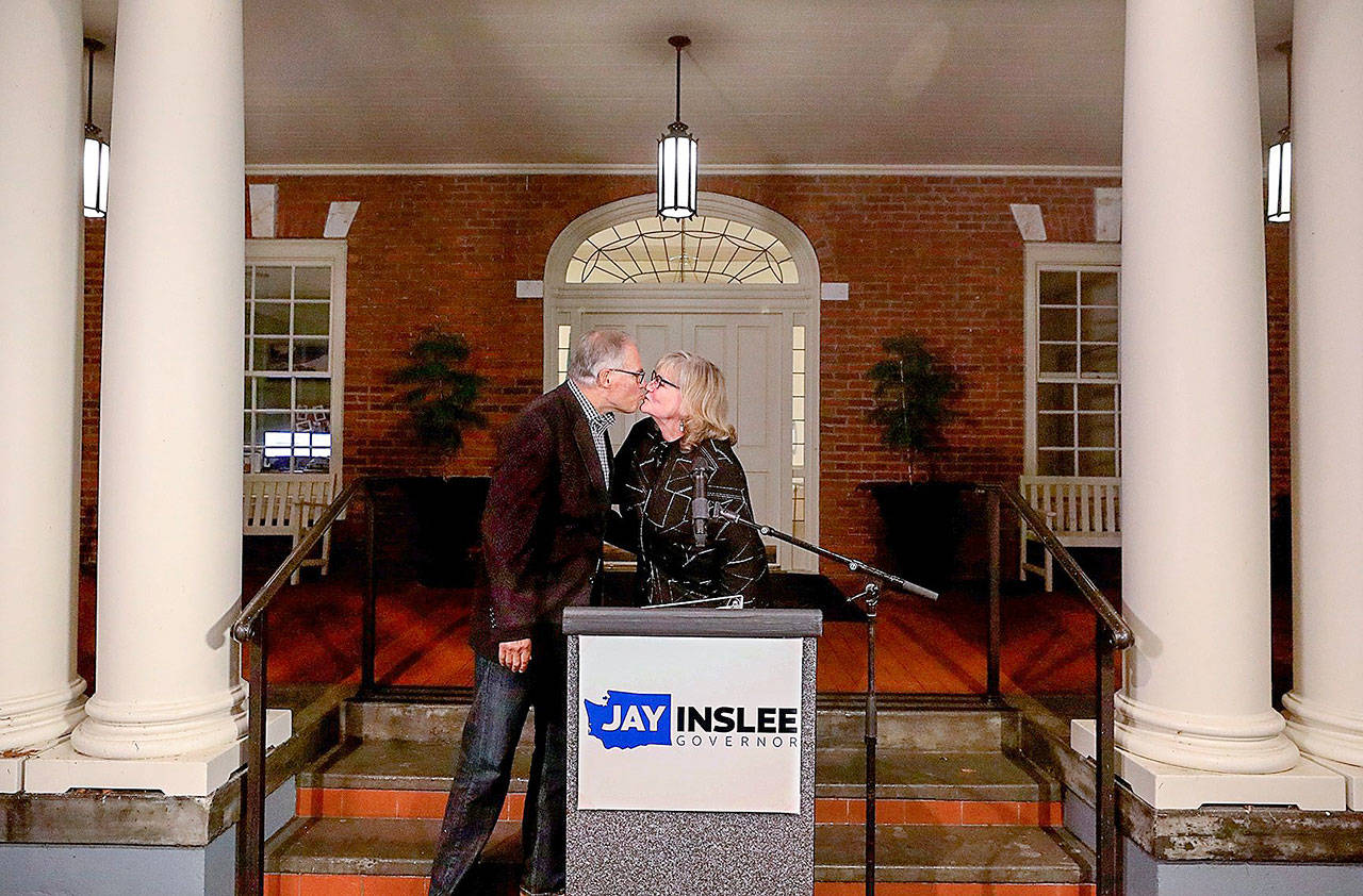 Gov. Jay Inslee kisses his wife Trudi after she introduced him following the Associated Press declaring him a winner for a third consecutive term. This on the porch of official residence on Tuesday Nov. 3, 2020. (Alan Berner/Seattle Times/TNS)