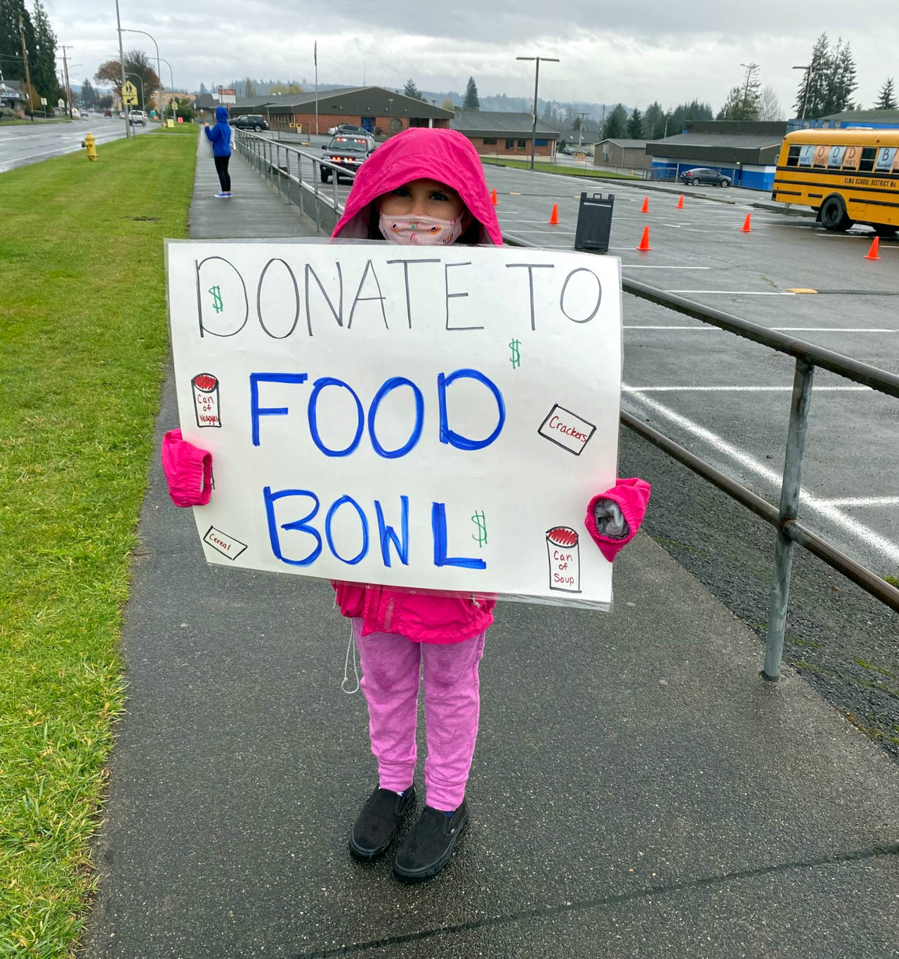 Elma fifth-grader Abigail Henry holds up a sign promoting donating to the Elma Food & Money Drive that took place Nov. 12-24. The event raised over $17,000 and 6,000 pounds of food benefitting food banks in Elma, McCleary and Malone. (Submitted photo)