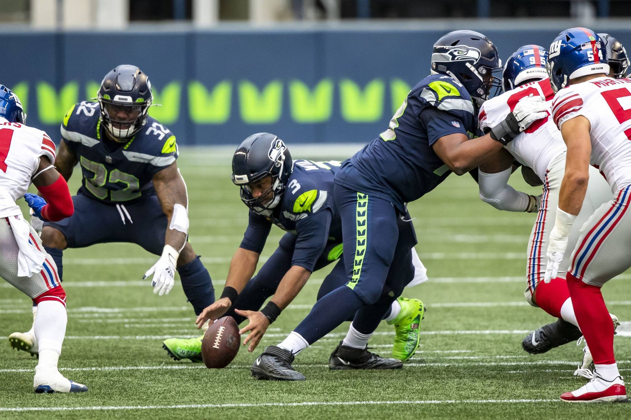 Bettina Hansen/The Seattle Times 
Seattle quarterback Russell Wilson fumbles the snap and the New York Giants recovered in the second quarter on Sunday at Lumen Field in Seattle.