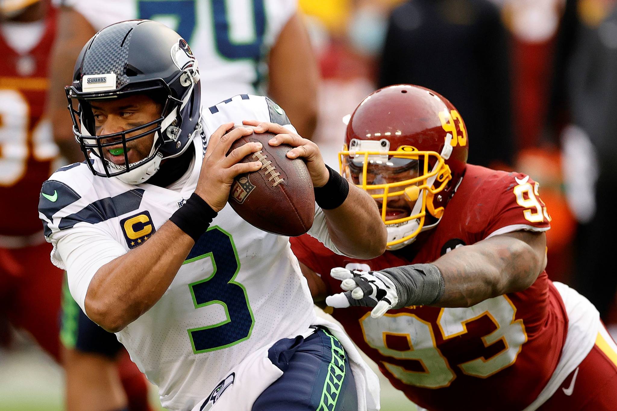 Tim Nwachukwu/Getty Images 
Seattle quarterback Russell Wilson eludes the tackle of defensive tackle Jonathan Allen of the Washington Football Team in the second half on Sunday at FedExField in Landover, Maryland.