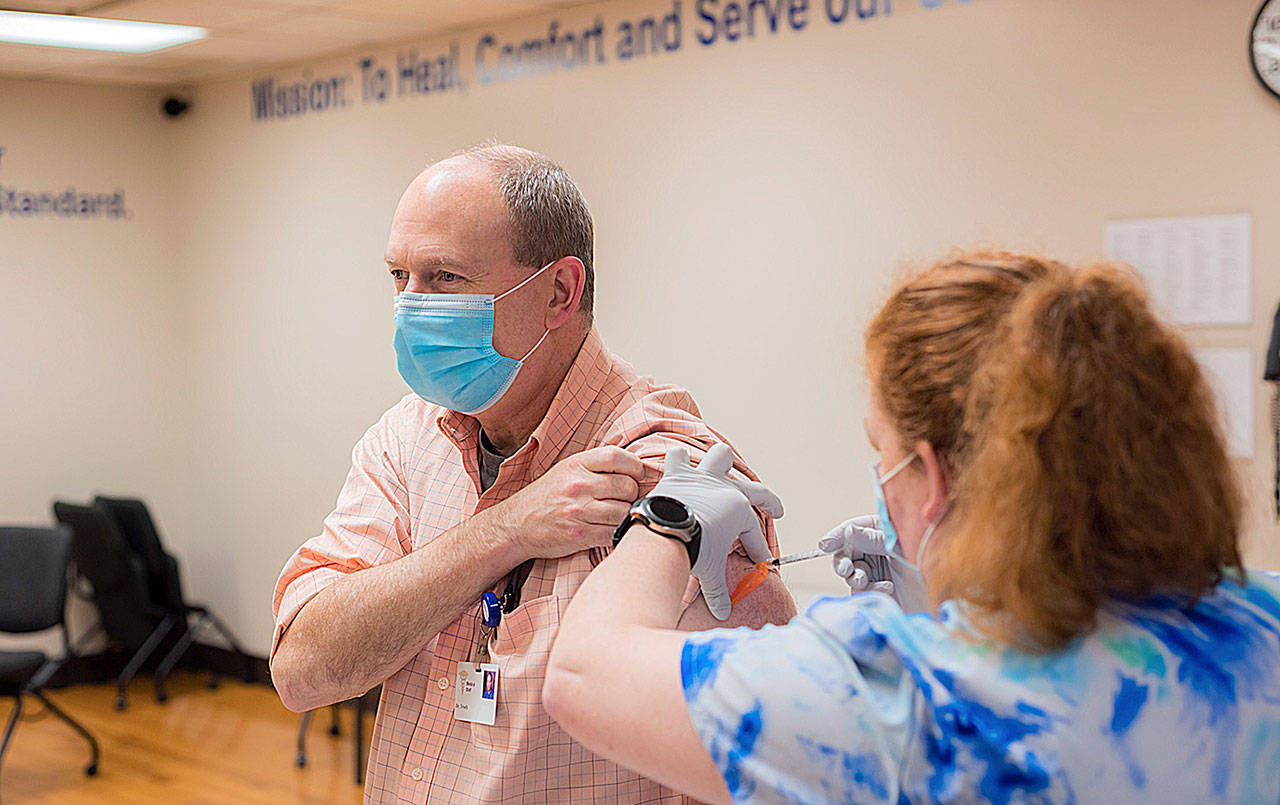COURTESY GRAYS HARBOR COMMUNITY HOSPITAL 
On the first full day of vaccinations, Hospitalist Timothy Troeh, MD, receives his first dose of the Pfizer vaccine at Grays Harbor Community Hospital.
