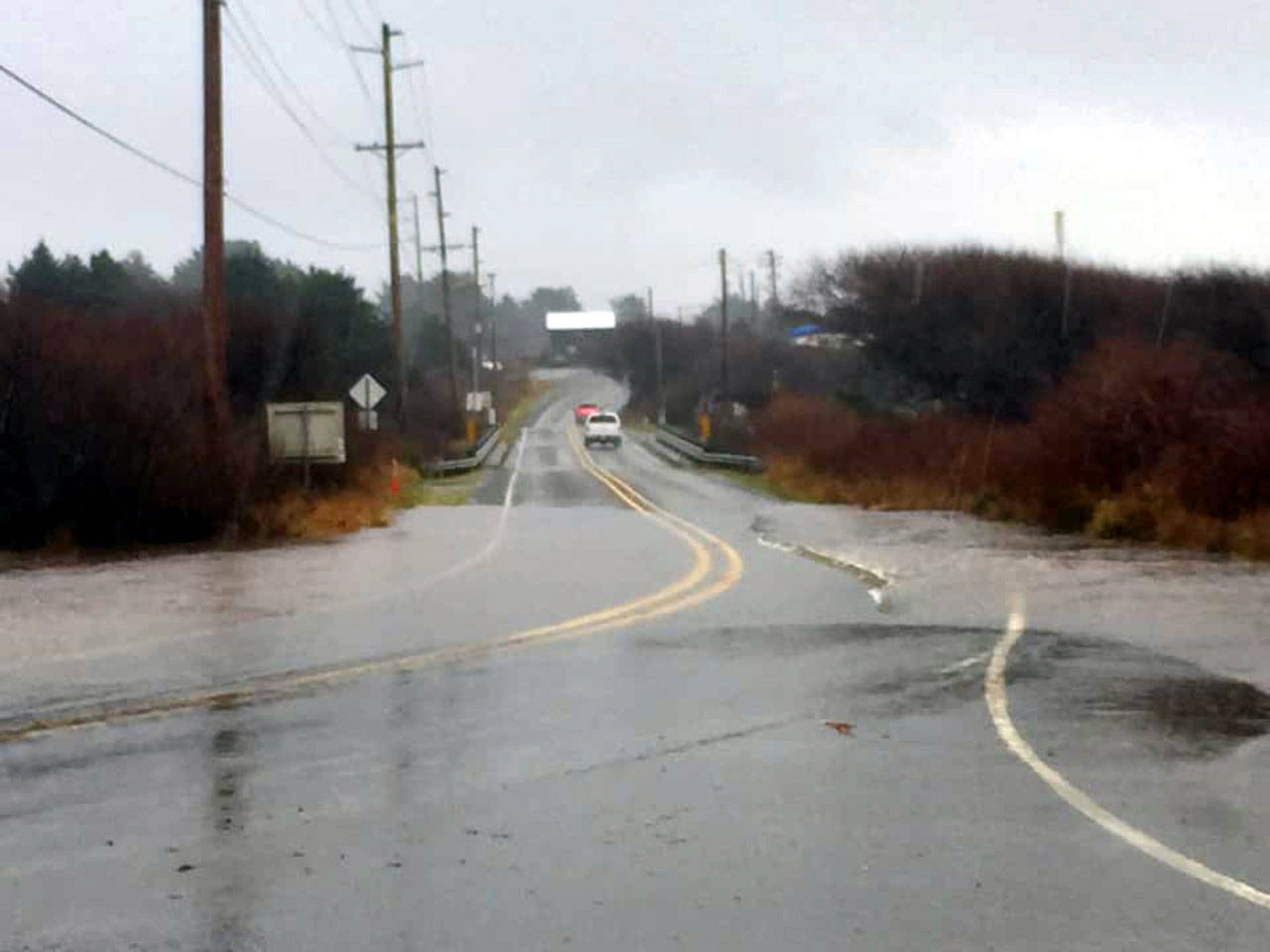 Some minor flooding creeps up onto the edge of State Route 109 near the Moclips River on Monday. Water on the roadway caused the route to be closed in both directions near Ocean City at 12:30 p.m. (Photo by Elizabeth Berg)