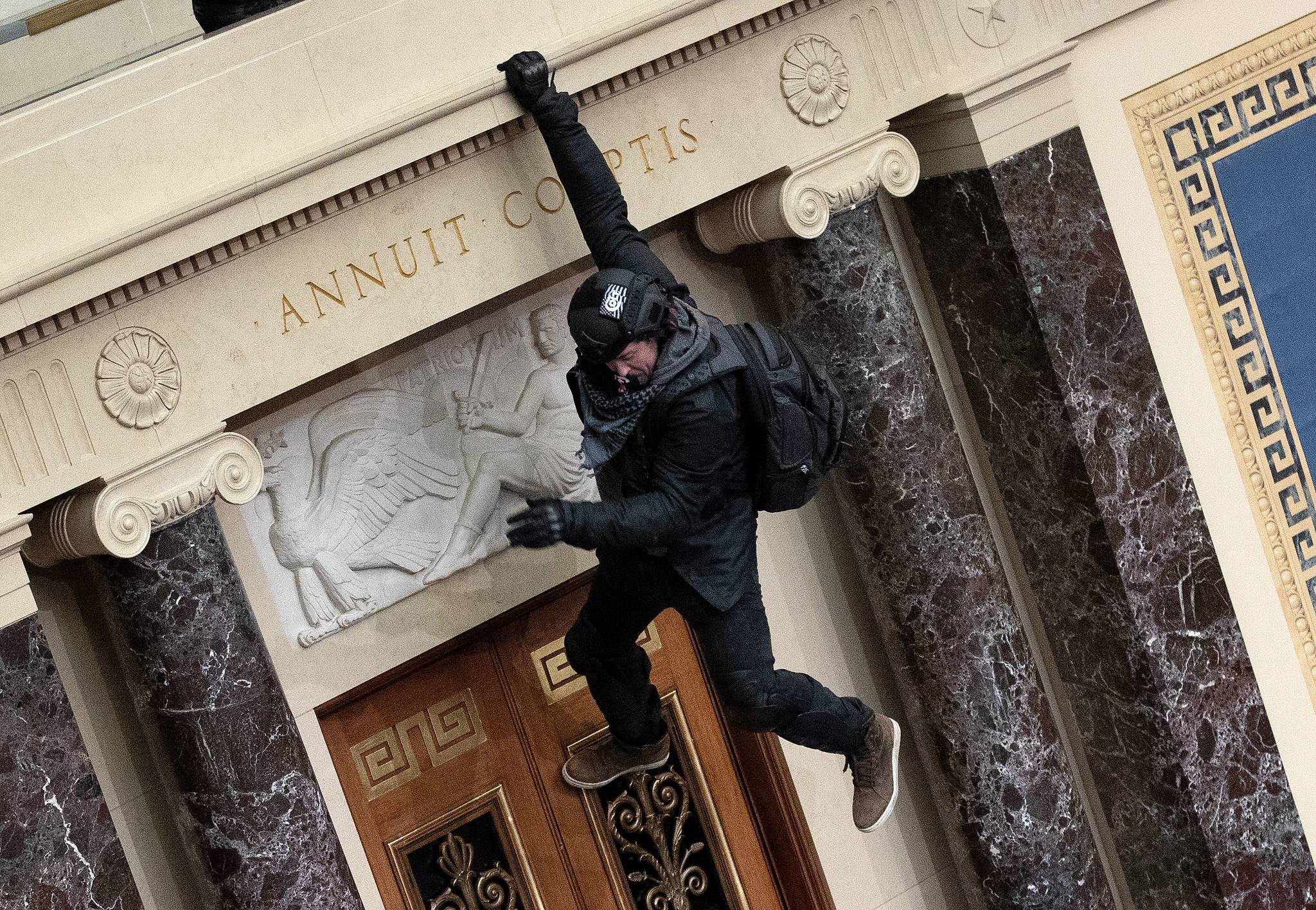 Win McNamee/Getty Images 
A rioter allegedly identified as Josiah Colt, 34, of Treasure Valley, Idaho, drops into the Senate Chamber on Wednesday, Jan. 6, in Washington, D.C.