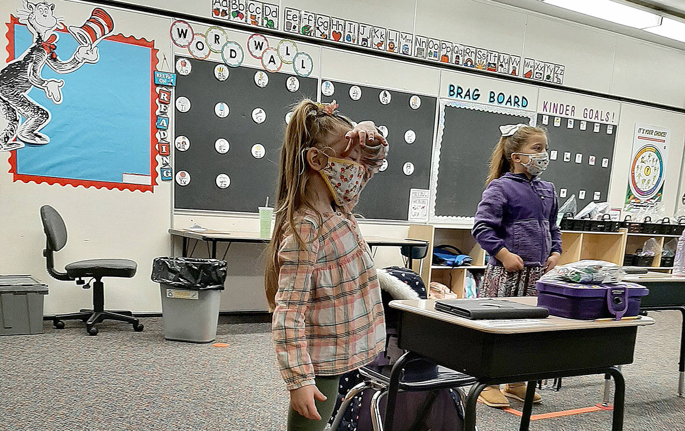 COURTESY PHOTO
Cosompolis kindergartners Ellie Adams-Bridges, left, and Madison Plummer practice standing in their social distancing spots during instruction, as Superintendent/Principal Cherie Patterson put it, “so they can get their wiggles out.”