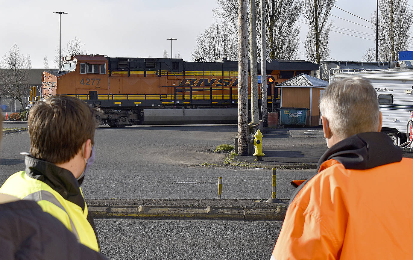 photos by DAN HAMMOCK / THE DAILY WORLD 
Aberdeen City Engineer Kris Koski, left, and Sen. Jeff Wilson watch a train cross South Newell Street in east Aberdeen Tuesday morning. Wilson was in town to get an update on the east Aberdeen rail separation project.