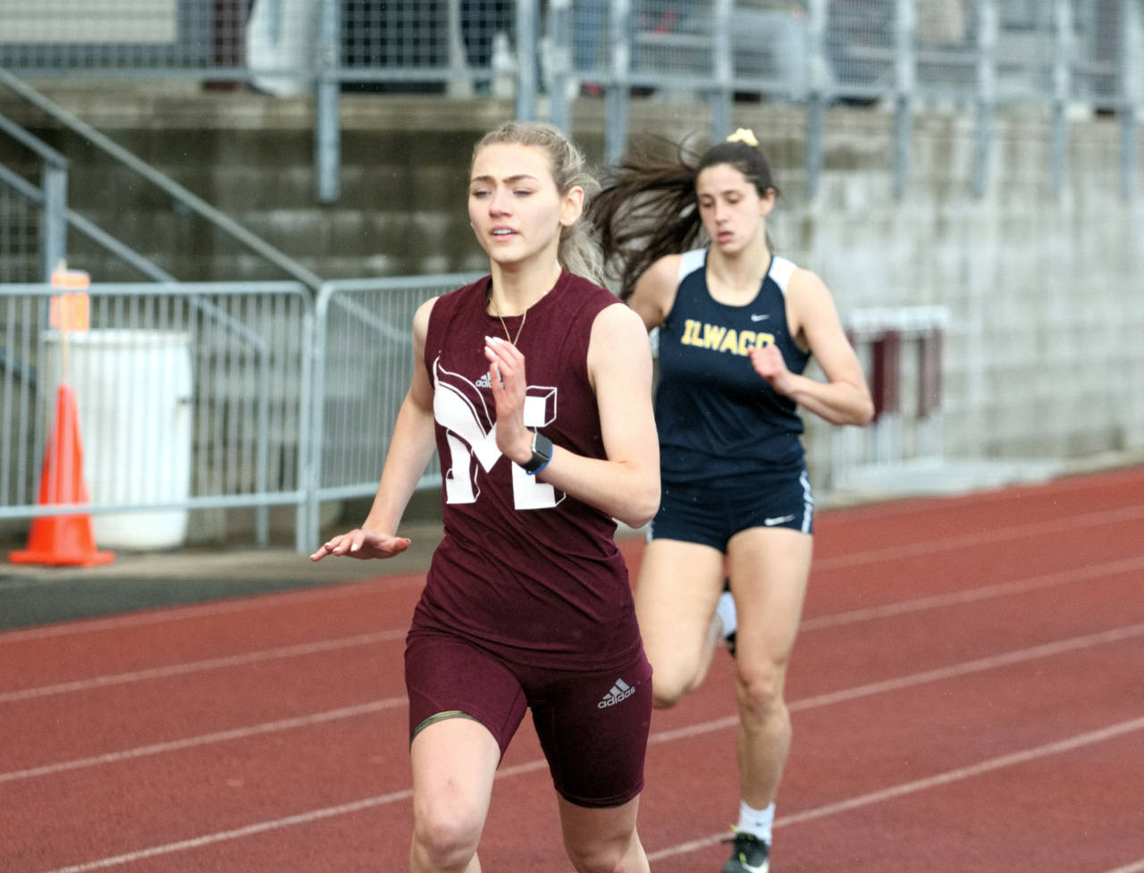 Montesano senior Madison Olson, left, sprints down the home stretch of the girls 400 meter race on Wednesday in Montesano. Olson edged Ilwaco’s Erika Glenn, right, by less than two seconds to win the race. (Ryan Sparks | The Daily World)