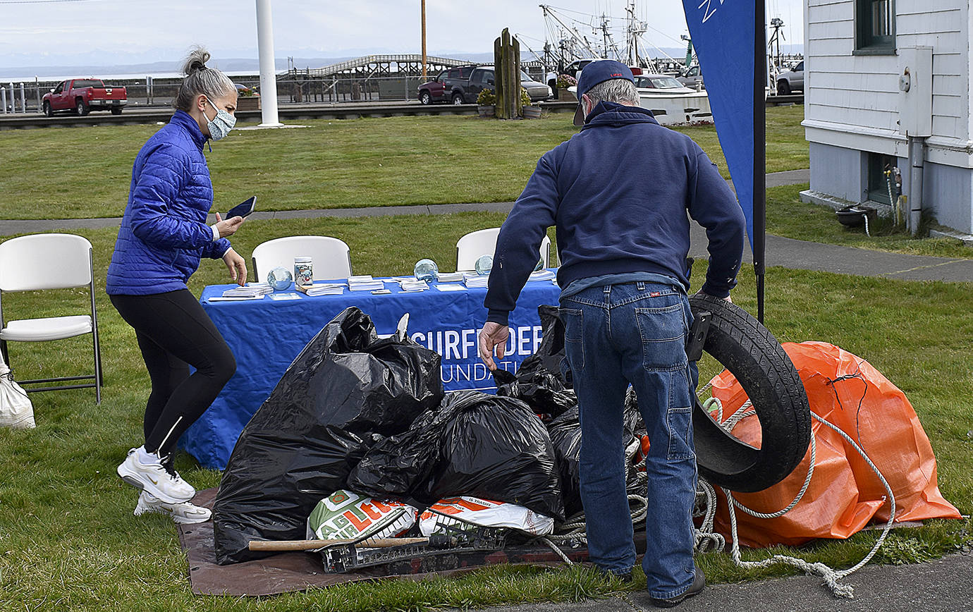 DAN HAMMOCK | THE DAILY WORLD 
Jill Williams, left, Vice Chair of the Olympia Surfriders, checks in trash collected at the south beaches Saturday at the Westport Maritime Museum.