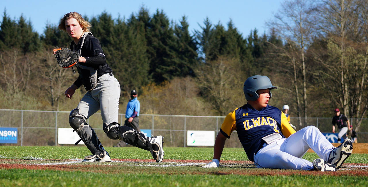 PHOTO BY ROB HILSON Ocosta catcher Andrew Martin left, tags out an Ilwaco runner during the Wildcats’ 13-9 loss on Friday in Long Beach.
