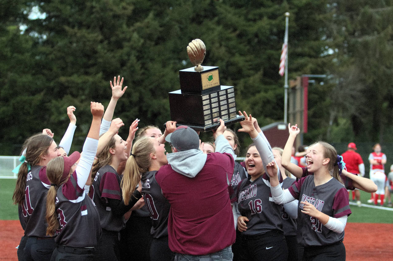 RYAN SPARKS | THE DAILY WORLD Montesano head coach Pat Pace, foreground, hands the district championship trophy to his team after they defeated Castle Rock 4-0 on Wednesday at Dick Tagman Field in Montesano.