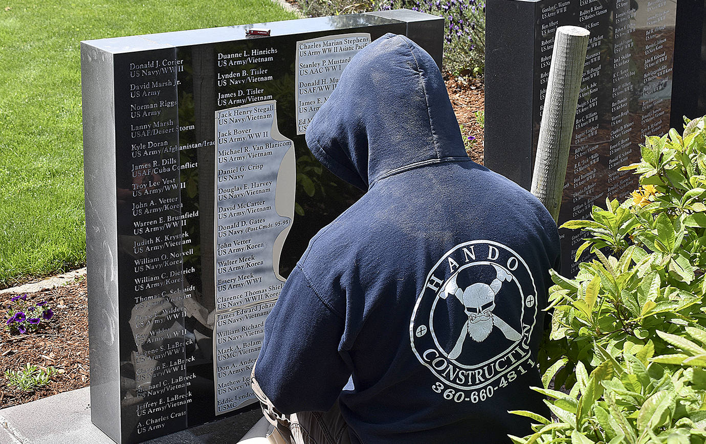 DAN HAMMOCK | THE DAILY WORLD 
Josh Warness with Grays Harbor Monument removes the stencil after engraving 22 new names into the Marion J. “Bogey” Bogdanovich Veterans Honor Wall in Montesano Thursday.