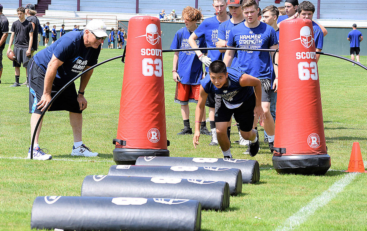 The annual Steve Paul golf tournament, dinner and auction to benefit Grays Harbor Youth Athletics and its annual free football camp, is July 10. Here, Doug English coaches at the camp at Hoquiams Olympic Stadium. English is a college football hall of fame inductee who played defensive tackle for the Detroit Lions from 1975-1985. (Courtesy Grays Harbor Youth Athletics)