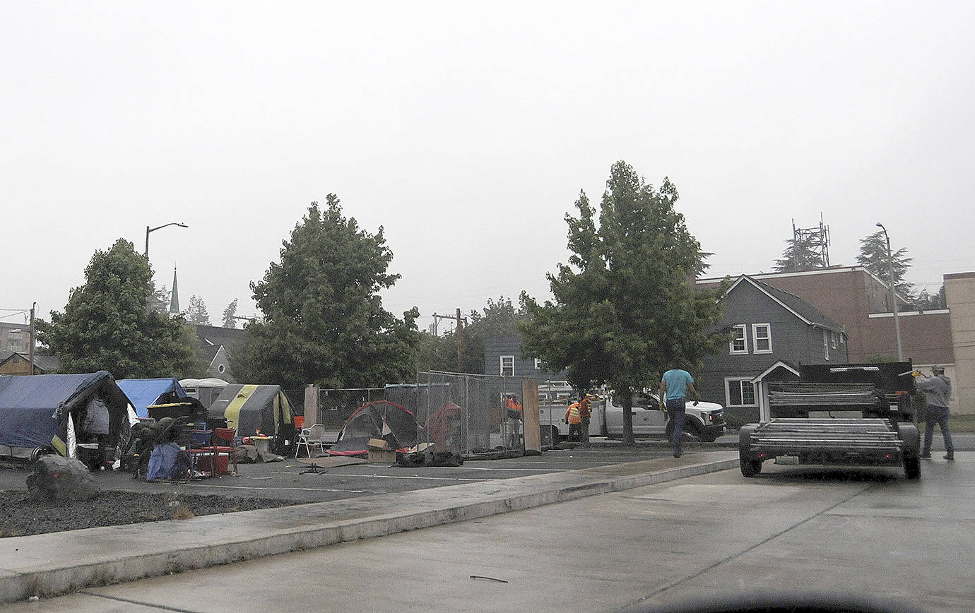 DAVE HAVILAND | THE DAILY WORLD 
A Bellevue-based company removes the fencing surrounding the homeless camp adjacent to Aberdeen City Hall Friday morning. The camp, known as TASL, was closed at noon Friday.