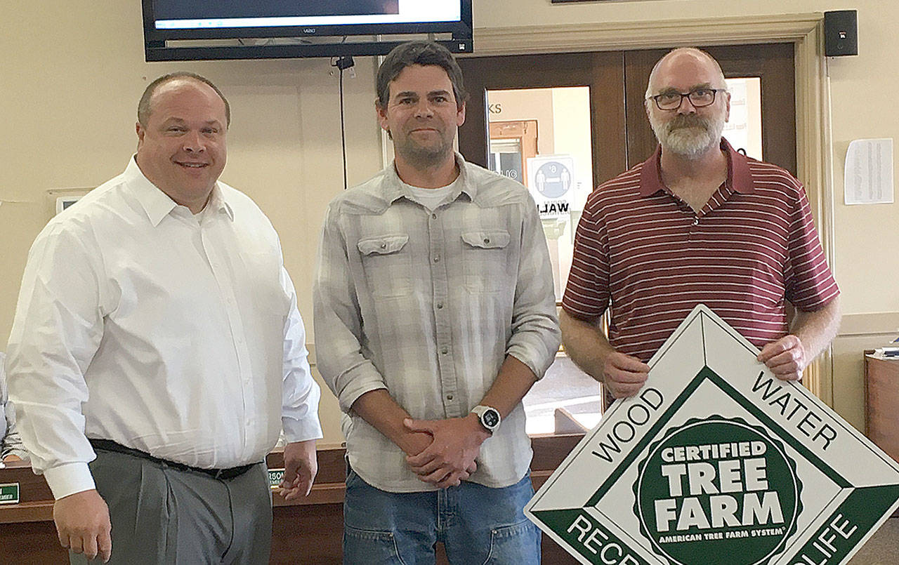 Courtesy City of Hoquiam 
Grays Harbor Conservation District foresters David Houk, center, and Jim Getchman, right, presented Hoquiam Mayor Ben Winkelman a marker for the city’s recently-certified watershed tree farm.