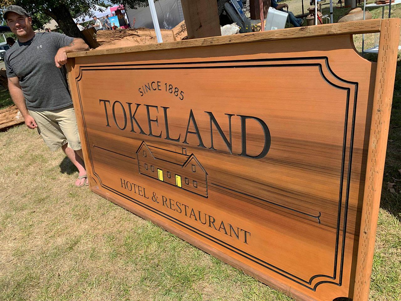 daily world File photo 
Shoalwater Bay woodcarver Earl Davis displayed this cedar sign he created for the Tokeland Hotel at the 2019 Tokeland Woodfest.
