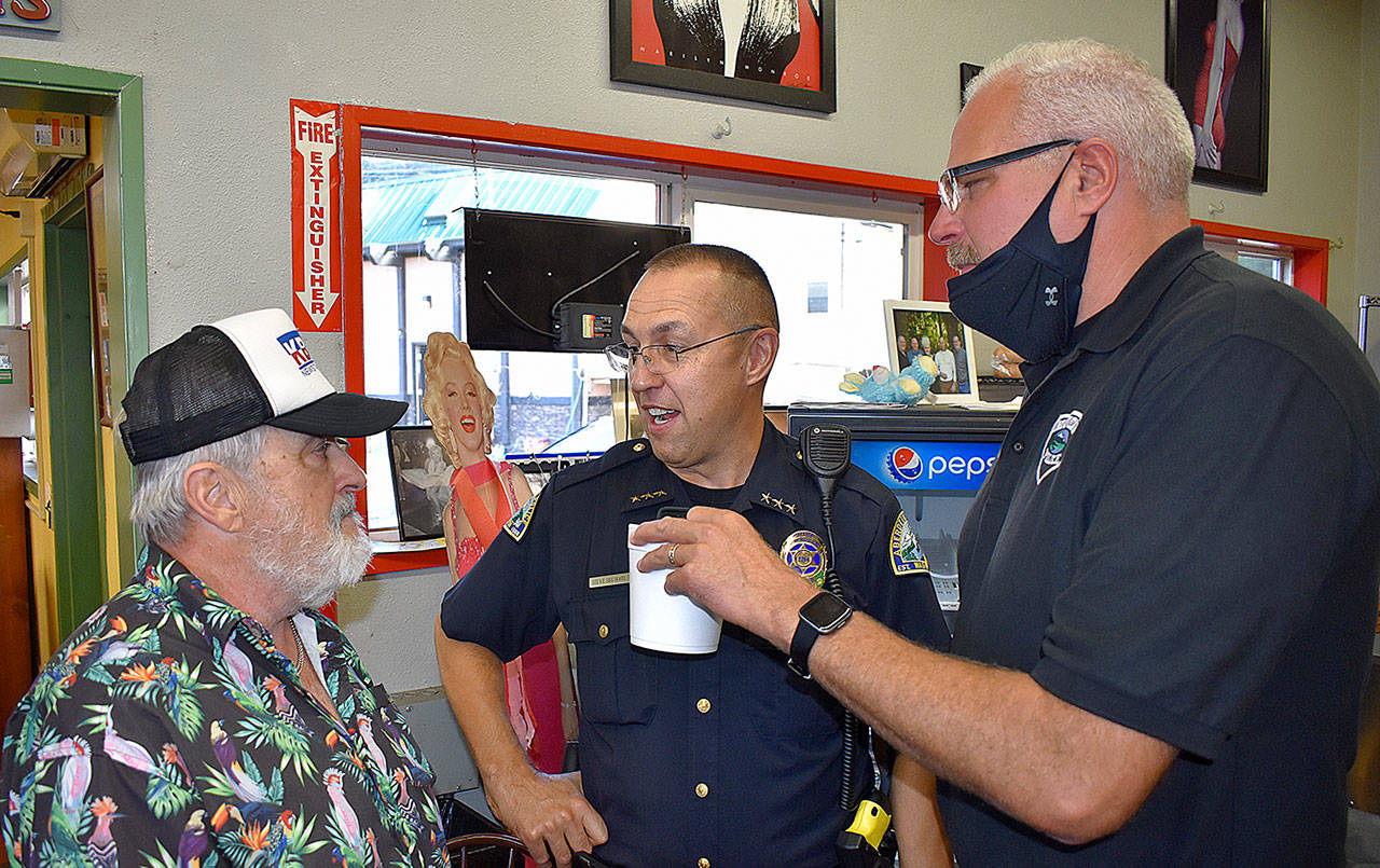 DAN HAMMOCK | THE DAILY WORLD 
Doug McDowell, left, chats with Aberdeen Police Chief Steve Shumate, center, and Hoquiam Police Chief Jeff Myers at McDowell’s final KBKW broadcast at the Hoquiam Farmer’s Market Tuesday morning.