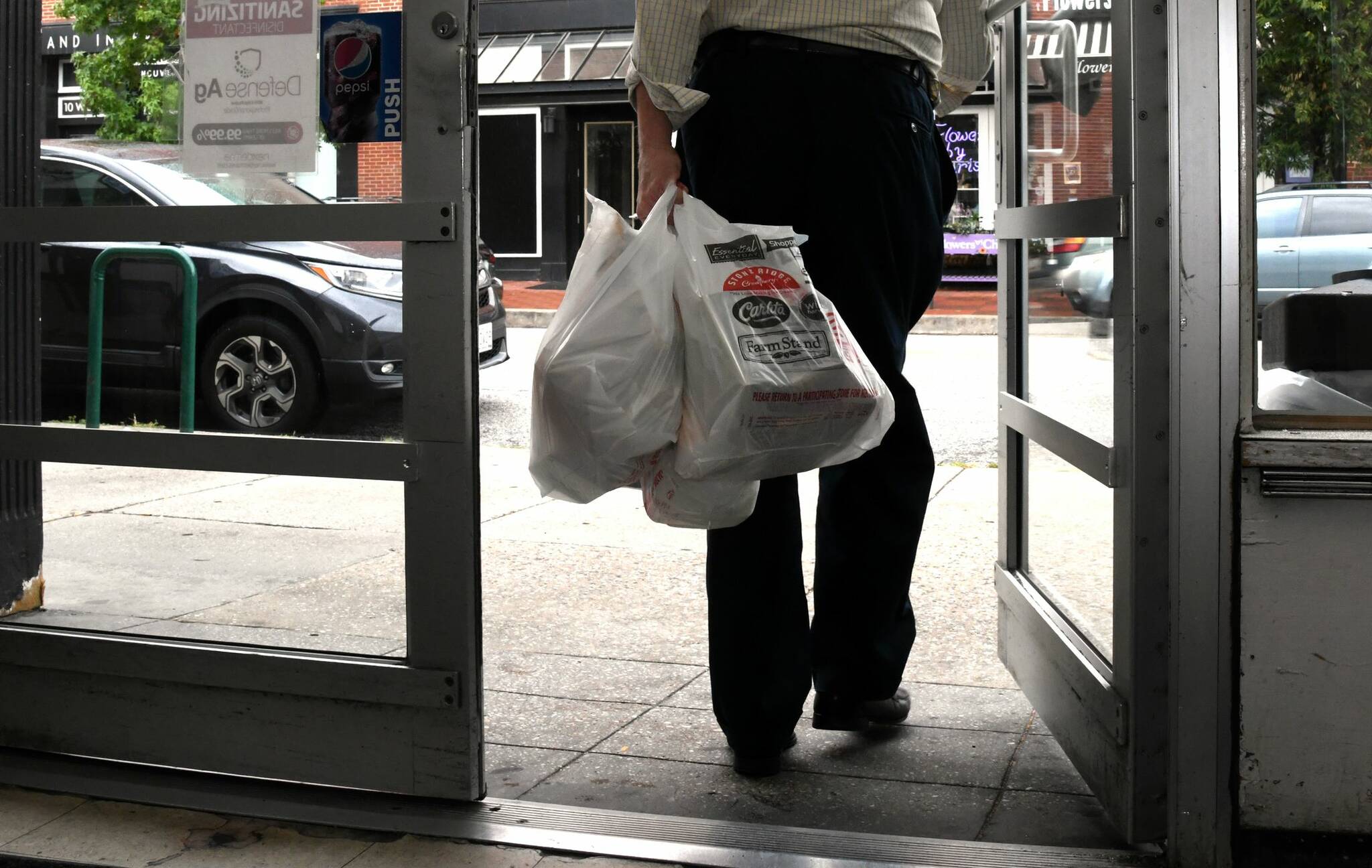 A customer leaves with plastic bags of groceries. Tribune News Service
