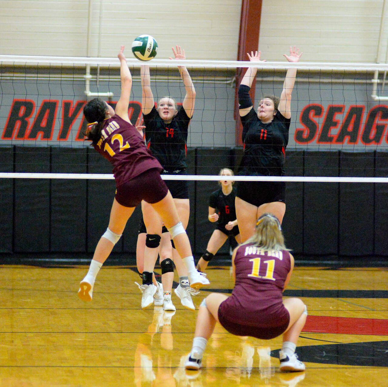 RYAN SPARKS | THE DAILY WORLD Raymond’s Grace Busenius (14) and Caton Swogger (11) attempt to block the shot of South Bend outside hitter Raydynn Morley during Tuesday’s game in Raymond.
