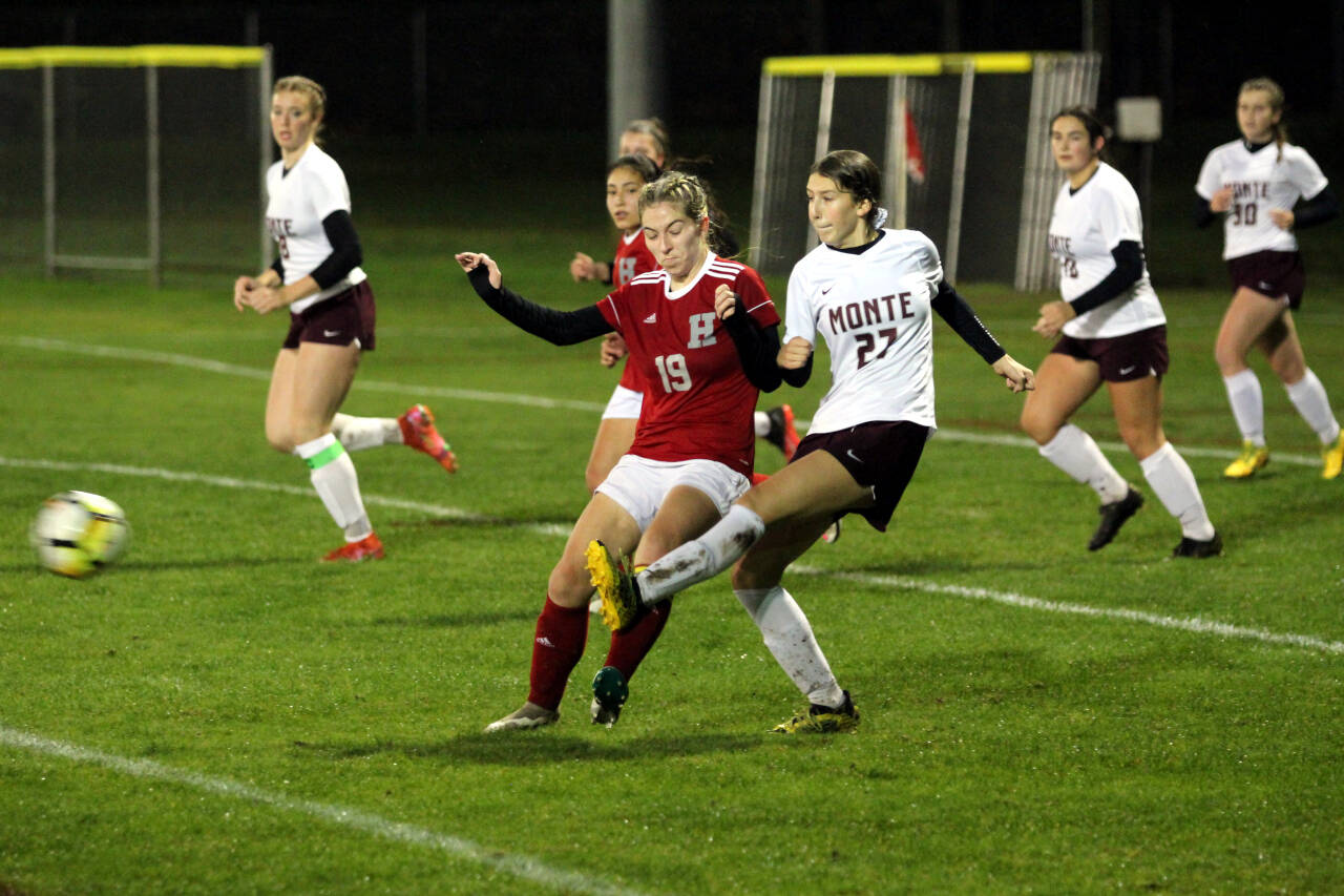 PHOTO BY BEN WINKELMAN Montesano forward Anabelle Estrada (27) sends the ball forward while being defended by Hoquiam midfielder Emma Johnson during the Bulldogs’ 8-0 win on Thursday in Hoquiam.