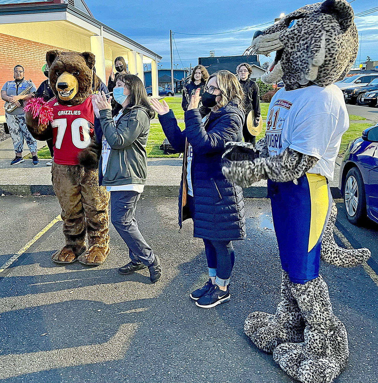 Courtesy of Coastal Harvest 
The final Food Ball numbers are celebrated by Hoquiam advisor Katie Barr, left, and Aberdeen advisor Ashley Kohlmeier, flanked by the Hoquiam Grizzly and Aberdeen Bobcat mascots, Monday, Nov. 8, 2021, at the Grays Harbor PUD office.