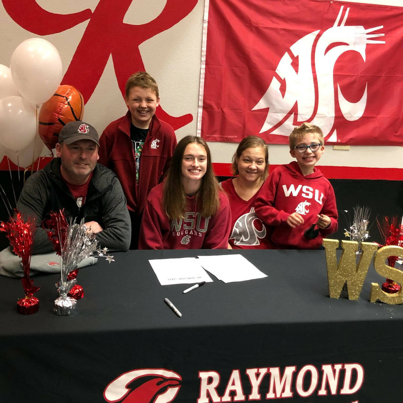 SUBMITTED PHOTO Raymond standout student-athlete Kyra Gardner, middle, is flanked by family members (from left) father Jamie, brother Thomas, mother Julie and brother Jordan during a ceremony on Tuesday after signing a National Letter of Intent to play women’s basketball at Washington State in the fall.