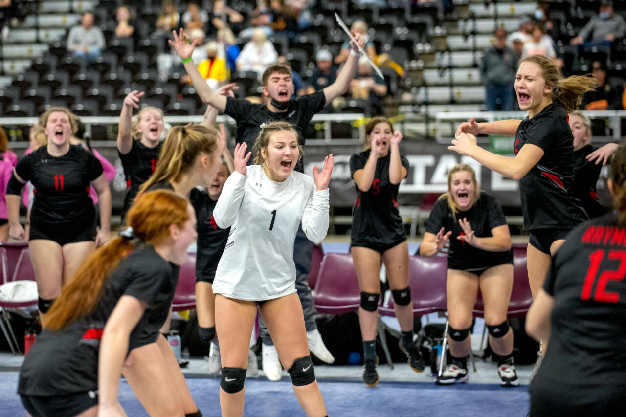 ERIC TRENT | THE CHRONICLE Raymond’s Kyndal Koski (1) and Karsyn Freeman, right, celebrate with their teammates after scoring a point against Walla Walla Academy in the 2B State Volleyball Tournament semifinals on Friday at the SunDome in Yakima.