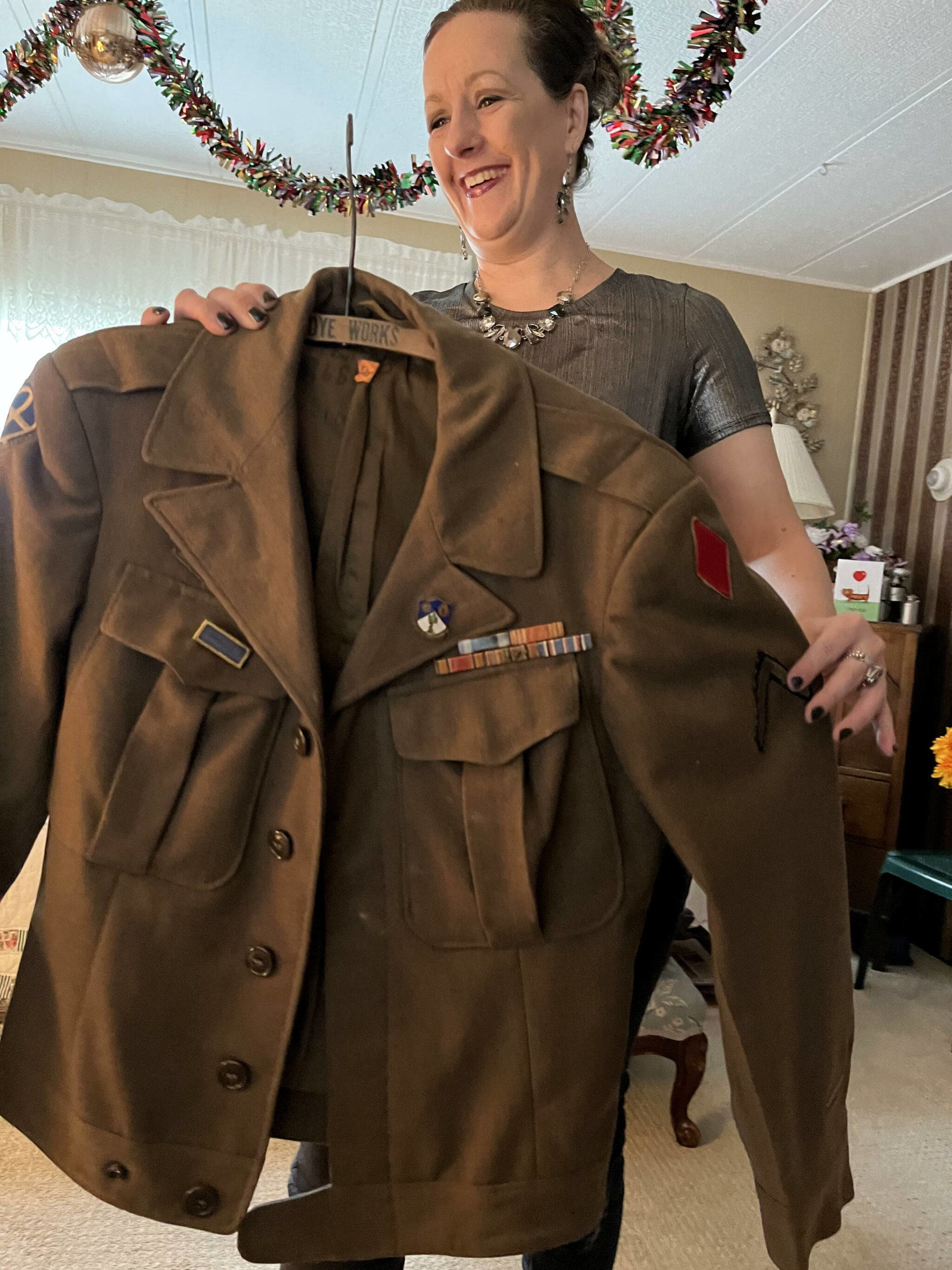Matthew N. Wells | The Daily World 
Jeri Bogar, proud as can be, brings out the U.S. Army uniform for her 97-year-old grandfather Harold Ralkey, Friday, Nov. 26, 2021, in Ralkey’s mobile home in Elma. The disabled veteran Ralkey served in the 5th Infantry Division in World War II. “He is the bravest and best man I know,” Bogar said.