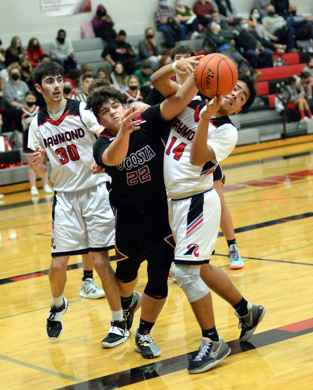 RYAN SPARKS | THE DAILY WORLD Ocosta’s Xander Prigmore (22) and Raymond Adrian Quintana (14) compete for a rebound during the Seagulls 87-53 victory on Wednesday at Raymond High School.