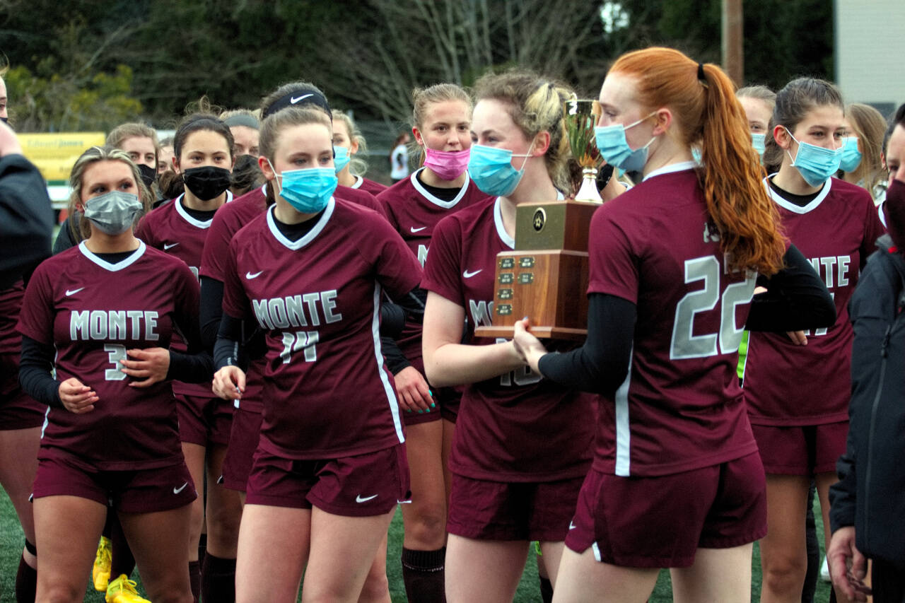 DAILY WORLD FILE PHOTO The Montesano girls soccer team hoist up its 1A District Championship trophy after winning the title against Tenino in March.