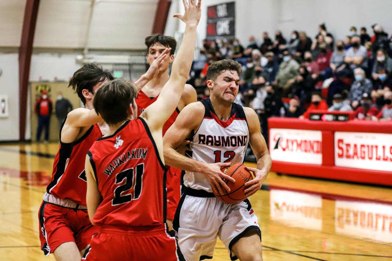 PHOTO BY LARRY BALE Raymond’s Tre’ Seydel (12) fights through the Wahkiakum defense during the Seagulls’ 74-56 victory in the first round of the 2B District 4 Tournament on Saturday in Raymond.
