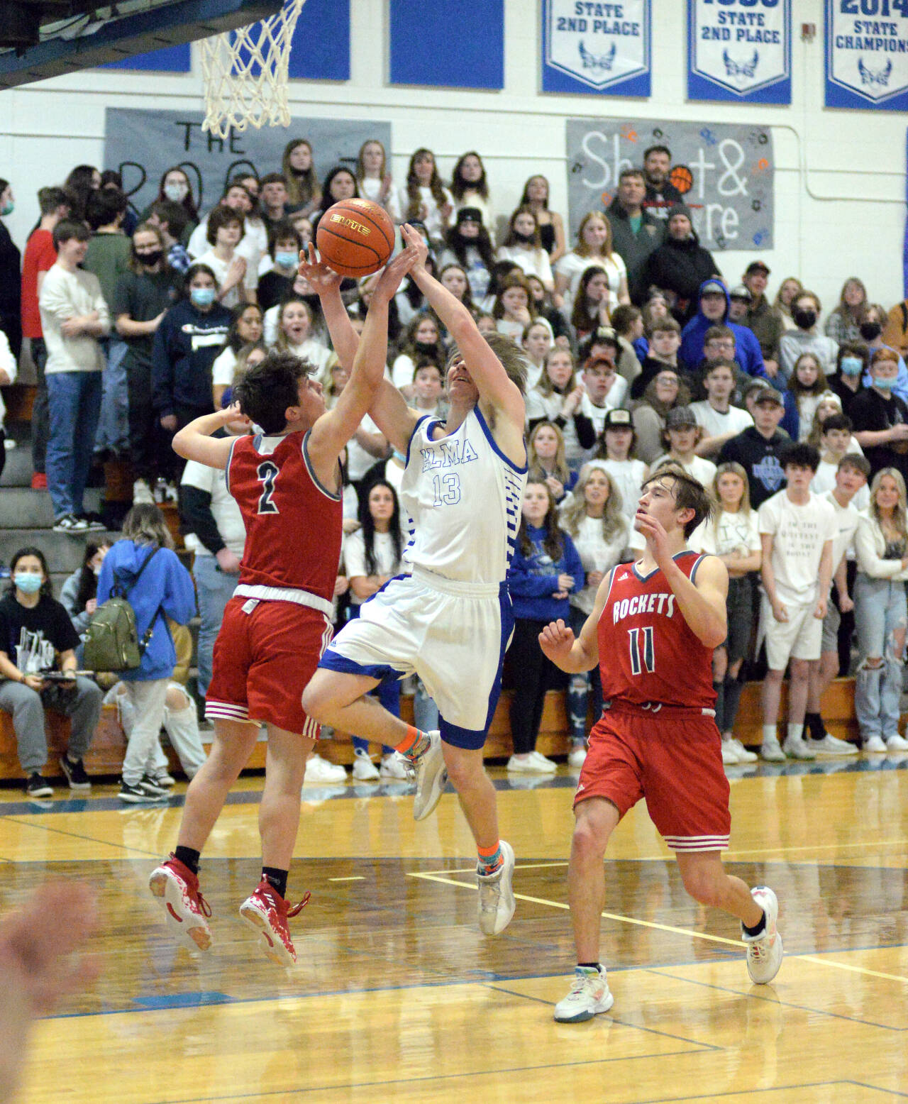 RYAN SPARKS | THE DAILY WORLD Elma’s Traden Carter (13) drives to the basket against Castle Rock’s Trevor Rogen (2) and Lane Partridge during the Eagles’ 57-47 loss in the 1A District 4 Tournament on Thursday in Elma.