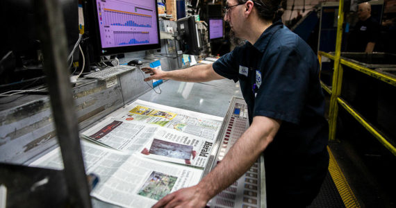 Olivia Vanni | The Daily Herald
Alex Hanson looks over sections of the Herald and sets the ink on Wednesday, March 30, 2022, in Everett.