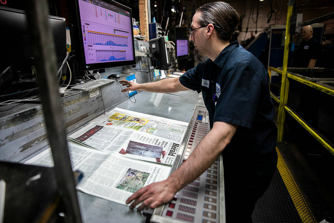 Olivia Vanni | The Daily Herald
Alex Hanson looks over sections of the Herald and sets the ink on Wednesday, March 30, 2022, in Everett.