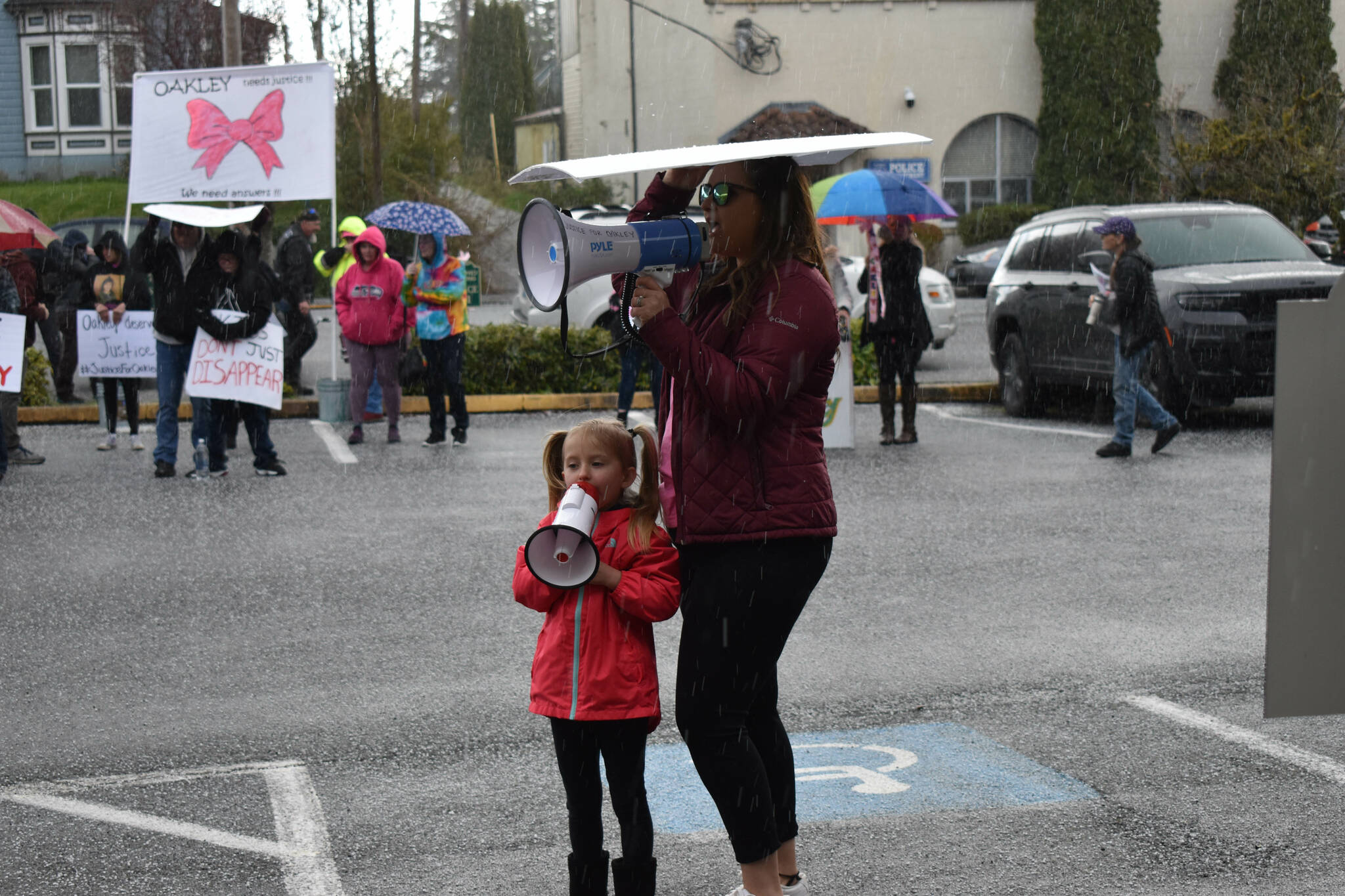 Five-year old Aubrey Wolfe shouts "Where is Oakley?" into her bullhorn beside her mother Jordan Wolfe, at the Gathering for Oakley, on Saturday, April 9, outside the Grays Harbor County Jail, in Montesano. Oakley's biological parents, Jordan Bowers and Andrew Carlson, are both inmates inside the jail. (Matthew N. Wells | The Daily World)