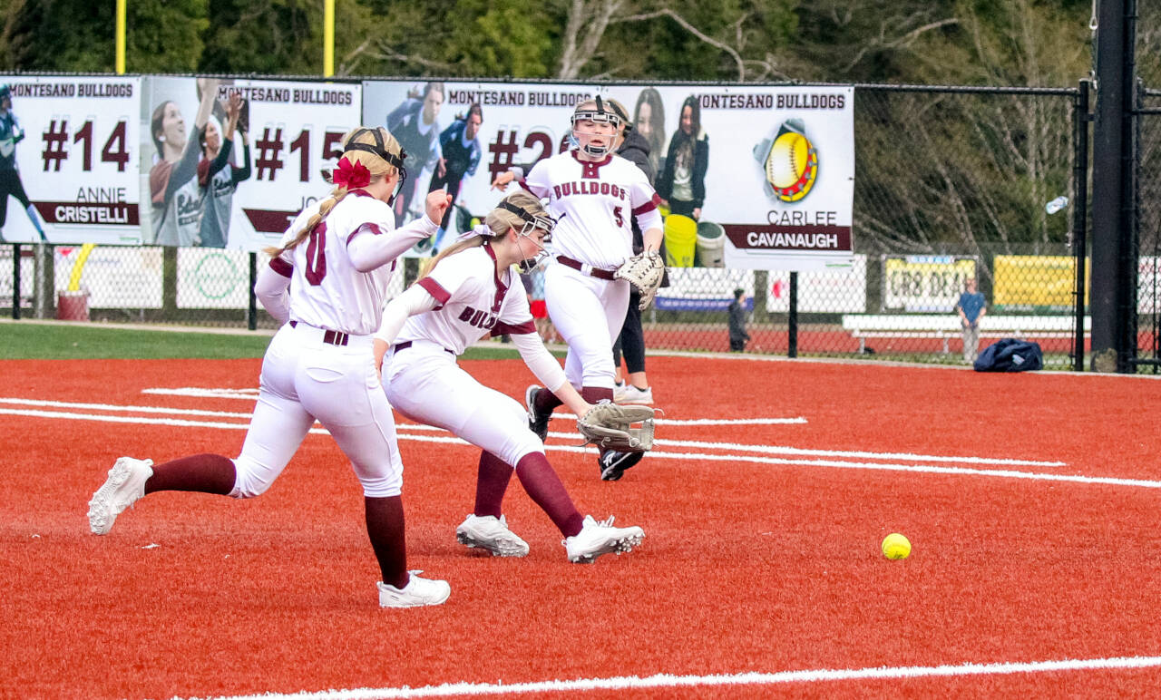PHOTO BY SHAWN DONNELLY Montesano pitcher Riley Timmons, middle, and Bulldogs infielders Addi Kersker (0) and Kylee Fairbairn (5) converge on a bunt during the first game of a doubleheader against Elma on Tuesday at Dick Tagman Field in Montesano.