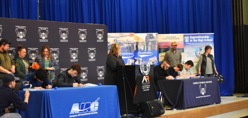 Allen Leister l The Daily World 
Students sign apprenticeship paperwork as their sponsoring company watches from behind during the AJAC Signing Ceremony at Elma High School on May 19, 2022, in Elma.