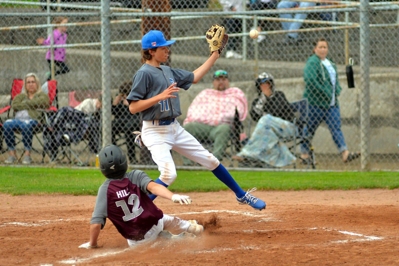 RYAN SPARKS | THE DAILY WORLD Montesano’s Mason Hill (12) slides in safe ahead of a tag by Elma’s Cole Gustafson during Montesano’s 17-7 win in the Little League Juniors District 3 Championship on Wednesday in Montesano.