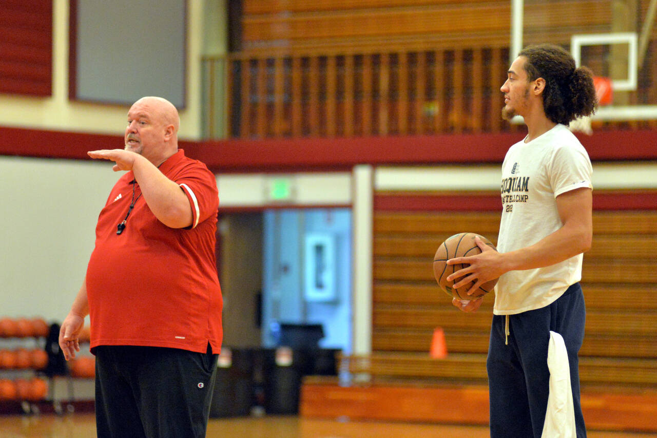 RYAN SPARKS | THE DAILY WORLD Hoquiam girls basketball head coach Chad Allan, left, and NBA player CJ Elleby talk to participants at the Hoquiam Youth Basketball Camp on Thursday at Hoquiam High School.