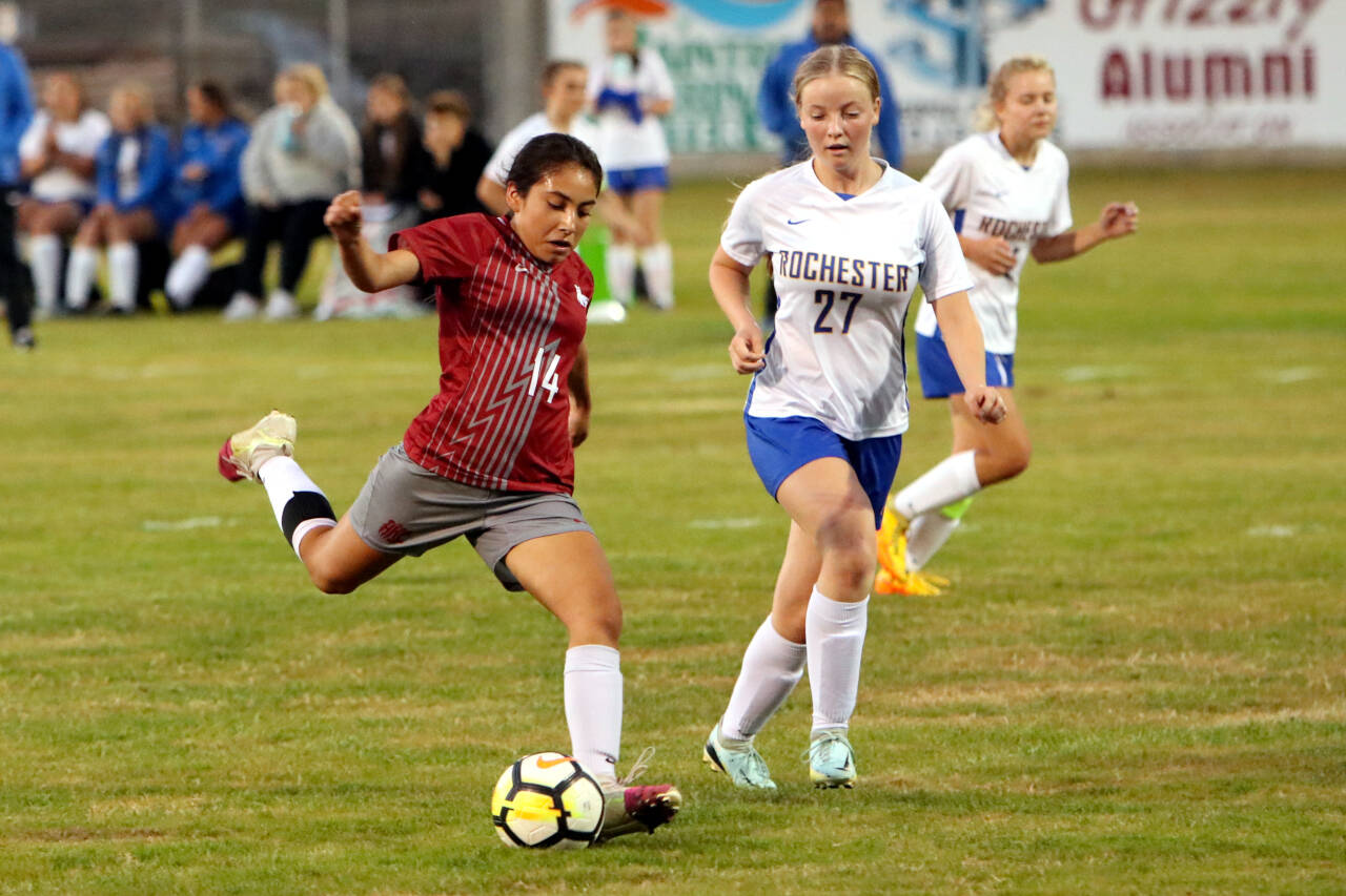 PHOTO BY BEN WINKELMAN Hoquiam senior midfielder Yazmin Garcia-Lopez (14) takes a shot while being defended by Rochester’s Madison Staley (27) during the Grizzlies’ 1-0 win on Tuesday, Sept. 20, 2022 at Olympic Stadium in Hoquiam. Gracia-Lopez scored the only goal in the game.