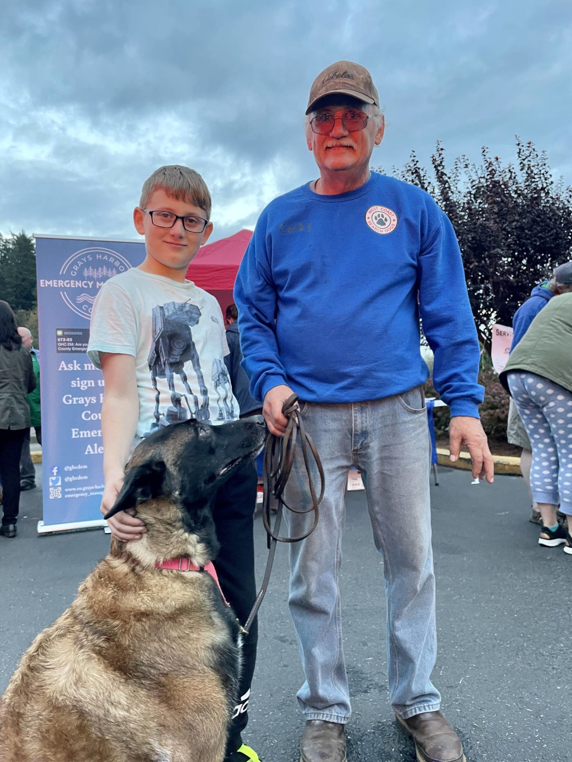 Michael S. Lockett / The Daily World
Harold Steinman, left, pets Hanna, a 7-year-old Belgian Malinois who, along with John Watkins, right, is part of the West Coast Search Dogs, at Badges & Brews, hosted at Starbucks.