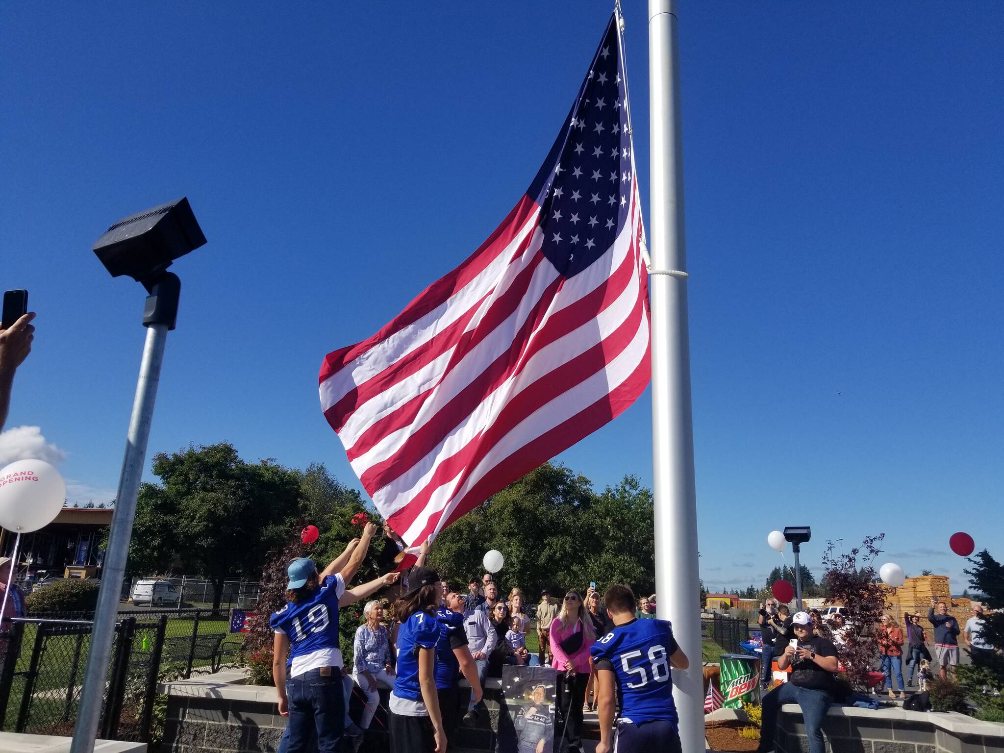 What originally started as a desire to install a flagpole slowly evolved into a flag pavilion with a dog park attachment. Elma High School football players were tasked with raising the ceremonial flag during the grand opening of the Martin Family Dog Park on Saturday, Sept. 24, in Elma. (Allen Leister | The Daily World)